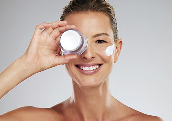 Image showing Face cream, skincare and portrait of a mature woman in a studio standing by gray background. Happy, smile and healthy lady doing beauty facial treatment with a clean, self care and wellness lifestyle