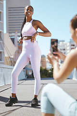 Image showing Fitness influencer friends with smartphone photo for social media update on wellness lifestyle and body progress results. Gen z marketing girl taking photo of black woman for sports fashion website