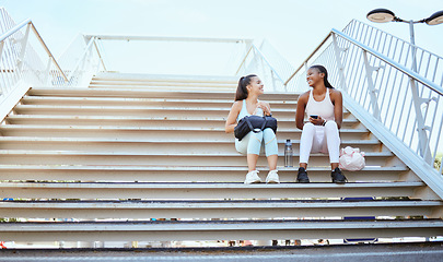 Image showing Friends, happy and relax after exercise on steps together, talking and bonding after morning cardio outdoors. Smiling, cheerful and females resting on stairs, enjoying free time after workout in city