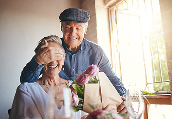 Image showing Love, flowers and surprise gift with elderly couple in celebration of a birthday or anniversary, happy and romantic. Family, marriage and senior man and woman celebrating their relationship together