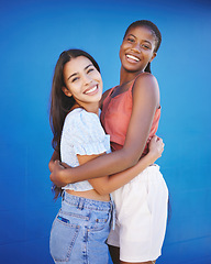 Image showing Diversity, friends and women hug with happy smile and woman friendship. Portrait of people smiling embracing love, happiness and female empowerment support in a studio with a blue background