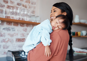 Image showing Care, love and mother holding sleeping baby with down syndrome in the kitchen of their house. Newborn child with development problem sleep with happy mom with smile and comfort in their family home