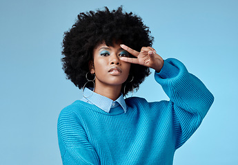 Image showing Portrait, young and black woman shows peace, sign and with blue studio background, afro and stylish look. Girl, happy lady and female with confident, relax and casual or funky outfit for fun day.