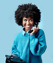 Image showing Landline, communication and black woman talking on a telephone against a blue mockup studio background. Happy, smile and young African model speaking to contact on a vintage phone with mock up space