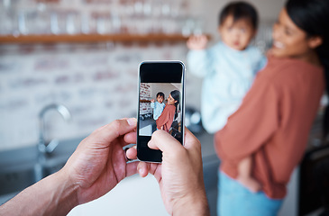 Image showing Father taking a picture of mother and baby on a phone in the kitchen of their family house. Love, care and man taking photo on smartphone of a happy and proud mom bonding with her child in their home