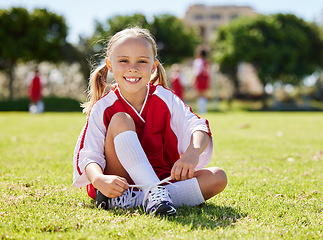 Image showing Soccer player, fitness and girl on field, soccer training and sports activity outdoor. Sport, health and exercise with child relax on grass, prepare for football game, checking shoes, happy and smile