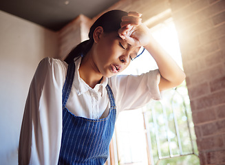 Image showing Woman, tired and apron tired from working in cafe, home or cooking job. Girl, chef and cook with headache from cooking burnout or work for service in cafe, kitchen or coffee shop in London