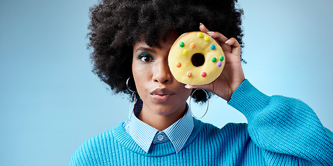 Image showing Beauty, black woman and donut portrait over face, celebration of Africa and sweet style on eye with blue background. Fashion, African model and cake with feminism, empowerment and excited happiness.