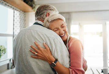 Image showing Hug, love and safe with a senior couple hugging or embracing in the kitchen of their home together. Happy, smile and affection with an elderly male and female pensioner sharing a warm embrace