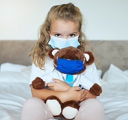 Image showing Covid, girl and teddy bear love and care for safety and awareness in pandemic quarantine at home. Portrait of a little kid playing doctor holding cute fluffy toy with mask for healthcare in pandemic