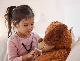 Image showing Stethoscope, girl and a teddy bear playing future doctor game showing care on a good health insurance checkup. Cute small child listening or checking stuffed animal medical heartbeat at home
