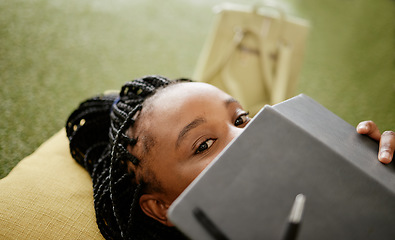 Image showing Black woman and student hiding face with notebook on casual college study lounge bean bag. Shy African university learner on studying rest break looking with lecture book to hide identity.