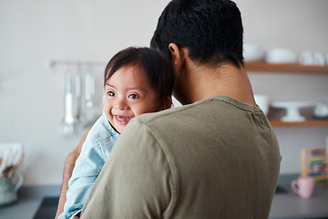 Image showing Down syndrome, baby and father bonding in a kitchen, happy and relax in their home together. Disability, development and child care for special needs with loving parent holding and comfort newborn