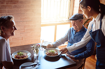 Image showing Happy senior couple at restaurant, waitress service with smile, and ready to eat healthy food with glass of champagne to celebrate anniversary. Woman in hospitality, serve lunch and drinks to people