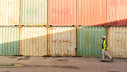 Image showing Shipping, logistics worker in shipyard port and walking by freight cargo containers. Transport of commercial goods, international delivery and inventory management creates a distribution supply chain