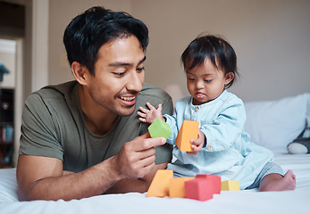 Image showing Baby, down syndrome and learning on a bed with child and father playing with educational blocks in a bedroom. Family, disability and kids bonding with asian parent, relax with creative activity