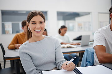 Image showing Education, university student and girl writing in classroom, lecture notes or studying for paper test. Learning, college and happy female smile with notebook and pen, exam or essay assignment on desk