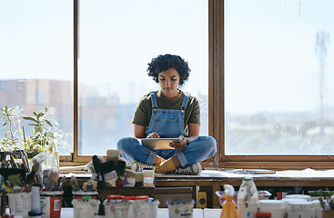 Image showing Creative, art and woman on digital tablet sitting by the window in her studio or workshop. Creativity, artistic and hipster girl artist doing research on the internet with mobile device in workspace.