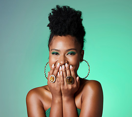 Image showing Beauty, green fashion and makeup with a black woman laughing in studio on a wall background. Portrait, happy and funny with an attractive female joking inside while her hands are on her face