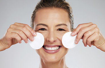 Image showing Mature, model and skincare with pads by face in hands for cleaning in dermatology, beauty or facial portrait. Woman, smile and skin happy against studio backdrop for cosmetics, health and wellness