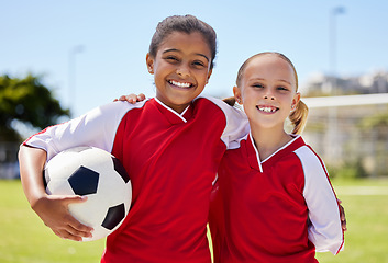 Image showing Portrait of girls on field, sports and soccer player, smiling with teammate. Soccer ball, football and young kids having fun on summer day before match or game. Team, friends and teamwork in sport