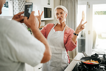 Image showing Senior couple cooking, smartphone taking portrait in kitchen and woman with v peace sign for social media, celebration of retirement or healthy lifestyle. Elderly people on cellphone with home photo