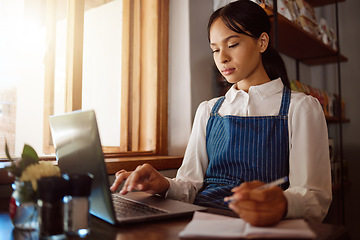 Image showing Coffee shop, laptop and finance with a woman manager or small business owner managing the books of her cafe. Startup, entrepreneur and management with a female working online in her restaurant