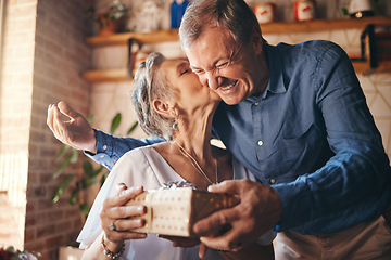 Image showing Elderly, couple and happy with gift, surprise and kiss on face together in home. Man, woman and retirement show love, romance and happiness giving present for anniversary, birthday or mothers day