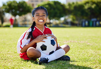 Image showing Sports, children and girl soccer player relax on grass with soccer ball, happy and excited at training. Fitness, smile and portrait of Indian child on field, ready for cardio, energy football workout