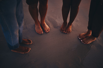 Image showing Friends, sand and feet at a beach at sunset, relax and bonding on summer vacation in nature. Toes, fun and people travelling and exploring at the sea, standing and enjoying holiday and friendship