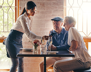 Image showing Phone, payment and restaurant with a senior man and woman payng a bill payment with NFC technology a waitress. Dating, romance and retirement with an elderly male and female pensioner in a cafe