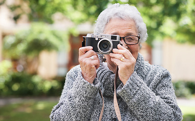 Image showing Retirement, relax and elderly woman with photographer hobby to enjoy pension leisure in garden. Satisfied, focused and senior lady with camera busy with nature photography outside nursing home.