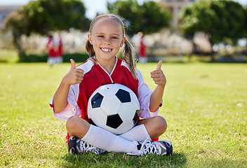 Image showing Ball, soccer and girl thumbs up on field, training and sports activity outdoor. Portrait of young sport athlete, health and exercise with child relax on grass, prepare for game, happy and smile