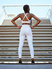 Image showing Exercise, workout and fitness black woman on a break at stairs after practice for health and wellness outdoor. Training, motivation or determined female with cardio routine for healthy or strong body