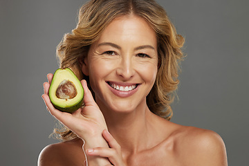 Image showing Skincare, avocado and smile on face of woman with fruit in hand for health, wellness and care. Model, skin and happy with avo in hand for healthy body, hair and beauty with facial product from nature