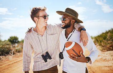 Image showing Friends, binoculars and football in a desert with men on a safari tour, bonding and enjoying freedom in nature. Happy, diversity and explore with diverse people laughing, hug and travel together