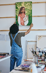 Image showing Painter, artist and wall hanging painting in studio to dry before exhibition, sale or display. Art, creative and woman with portrait of girl in paint in workshop with canvas, brush and color in Paris