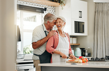 Image showing Senior couple in kitchen, cooking healthy food together and happy in retirement lifestyle. Elderly woman chopping vegetables with apron, old white man hug wife in home and love nutrition dinner meal