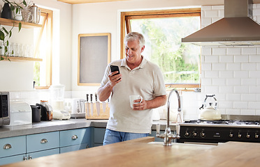 Image showing Senior man, morning coffee and phone looking happy while reading text message, online news or browsing internet in kitchen at home. Male using messenger or social media mobile app in Australia house