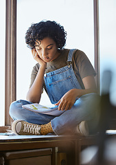 Image showing Young woman, reading book and relaxing on a window sill looking calm, focus and peaceful at home. Smart female student studying literature or educational book in her free time in her cozy apartment