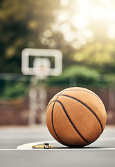 Image showing A ball used for basketball on an outdoor basketball court in a park. Mockup for sport, training and getting ready to play a match for exercise. Summer, sports and playing games outside to keep fit