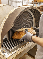 Image showing Worker grate bread crust