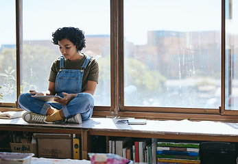 Image showing Tablet, creative woman and on table and at window using digital device for social media apps, texting and chatting during break. Girl artist or female student browse online, play game and relax.