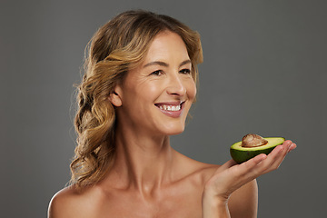 Image showing Woman, happy and avocado in hand for health, wellness and detox care with face. Mature model, dermatology and smile with fruit diet for skincare, hair and beauty with natural facial cosmetic product