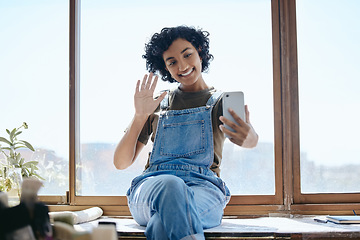 Image showing Phone, selfie or video call with a woman on social media while sitting on a table by a window inside with a wave. Communication, networking and internet with a young female using wifi technology