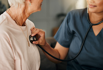 Image showing Cardiology consultation, doctor and senior woman consulting about healthcare on living room sofa in retirement home. Hand of nurse with stethoscope while helping elderly patient with medical service