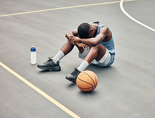 Image showing Basketball man, sports burnout and game fatigue on court sport training, muscle injury from exercise on ground and sad with mistake. Sick, depressed and african american athlete with competition pain