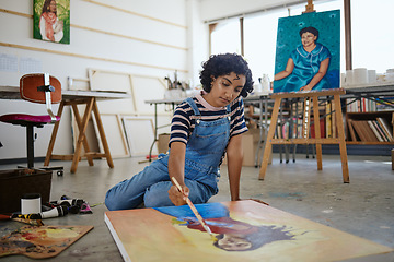 Image showing Painter, woman artist and creative on floor painting canvas in studio, workshop and gallery. Girl, lady or female create artistic piece with paint brush in workspace relax, focus and content with art