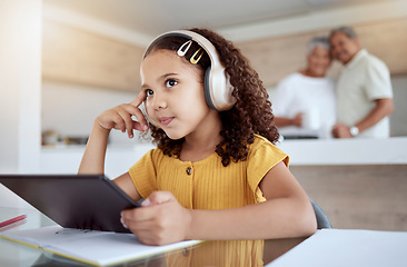 Image showing Children, tablet and education with a girl thinking while distance learning using headphones for home school. Idea, study and technology with a female student in her grandparents house to learn