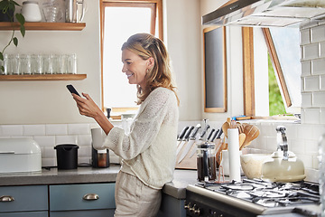 Image showing Mature woman reading phone news, social media notification and mobile apps in Australia kitchen home. Happy lady typing smartphone, online social network and 5g web technology connection in apartment